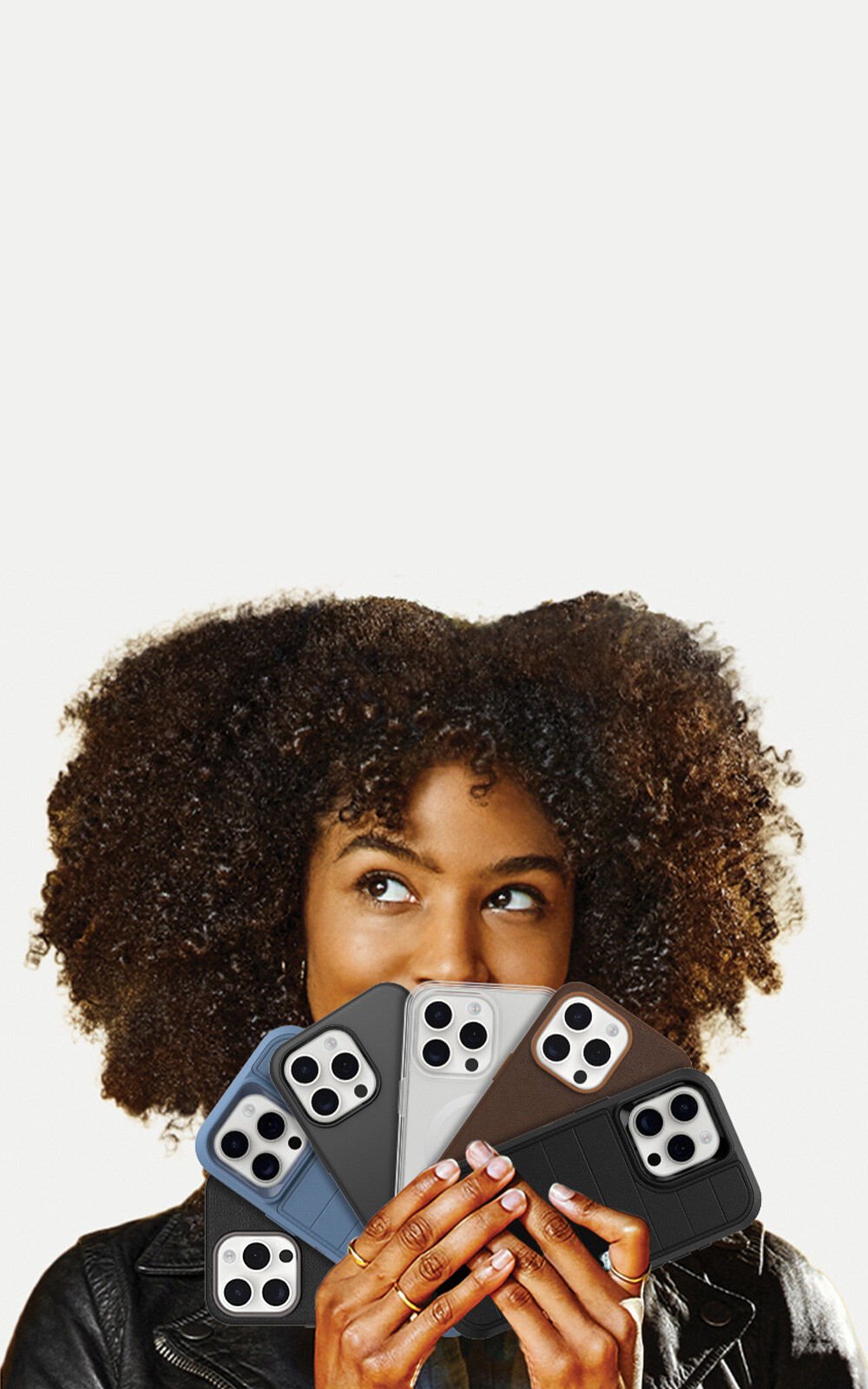 Person holding four different colored phone cases against a white background