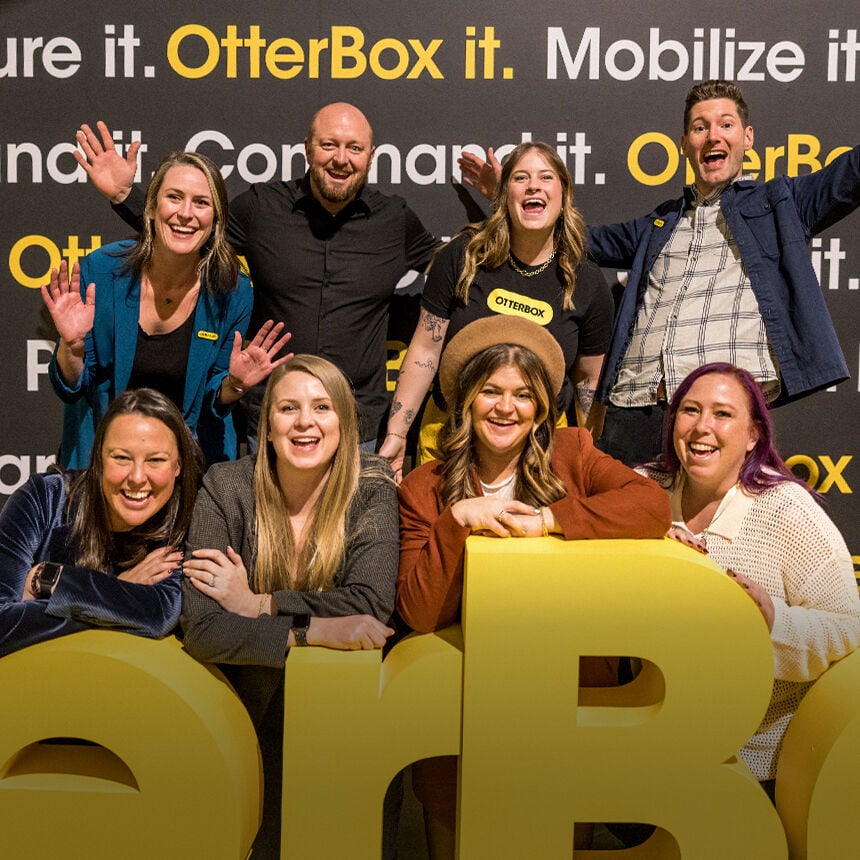 Group of people posing together in front of an OtterBox branded backdrop