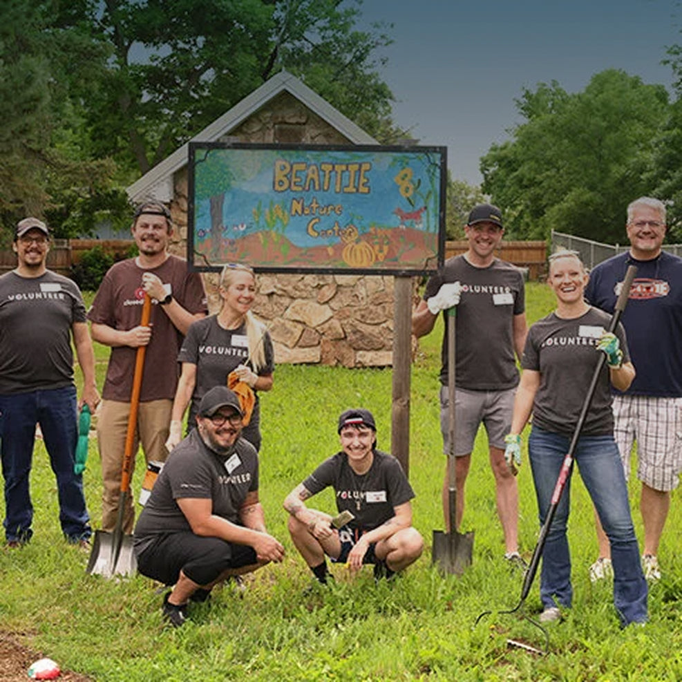 Group of volunteers posing in front of a sign for Beattie Nature Center.