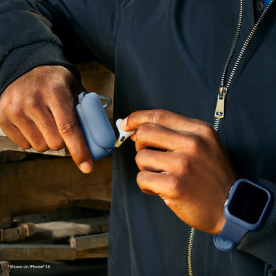 Person wearing a dark jacket with a blue airpods case.